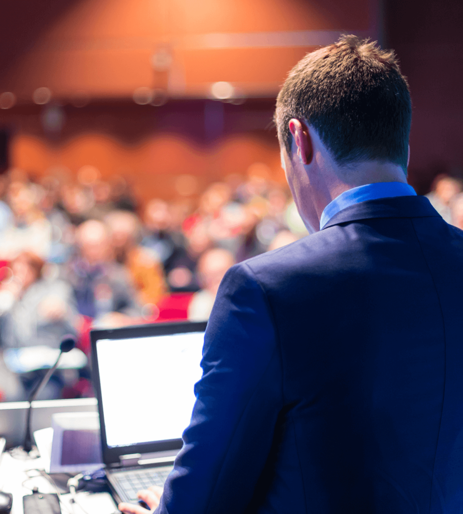 Speaker giving a lecture with computer at a podium